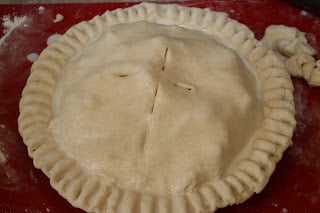 Unbaked pie with sealed edges and glaze.