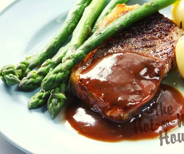 Espanole brown sauce over steak with asparagus and potatoes