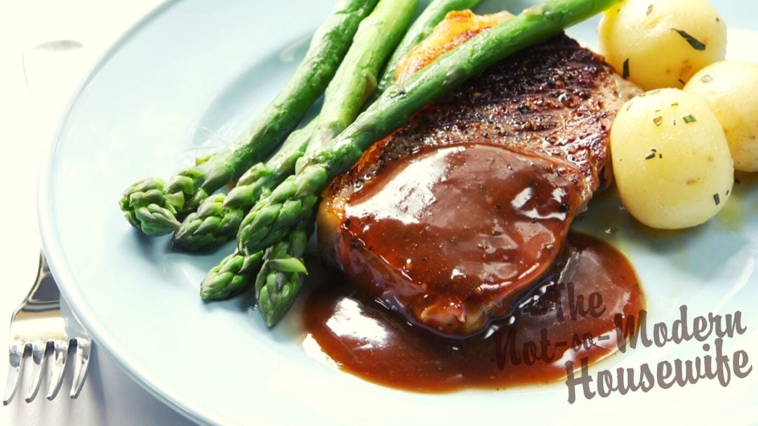Espanole brown sauce over steak with asparagus and potatoes