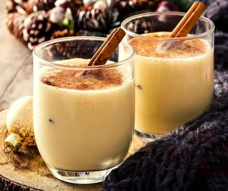 Eggnog with ground nutmeg and a cinnamon stick