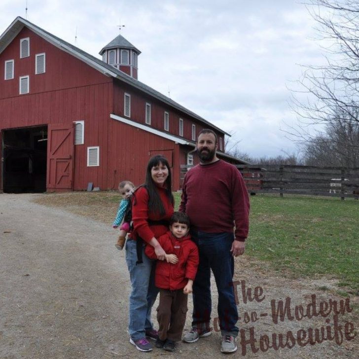 homesteading family standing in front of red farm barn - why I chose to become a homesteader