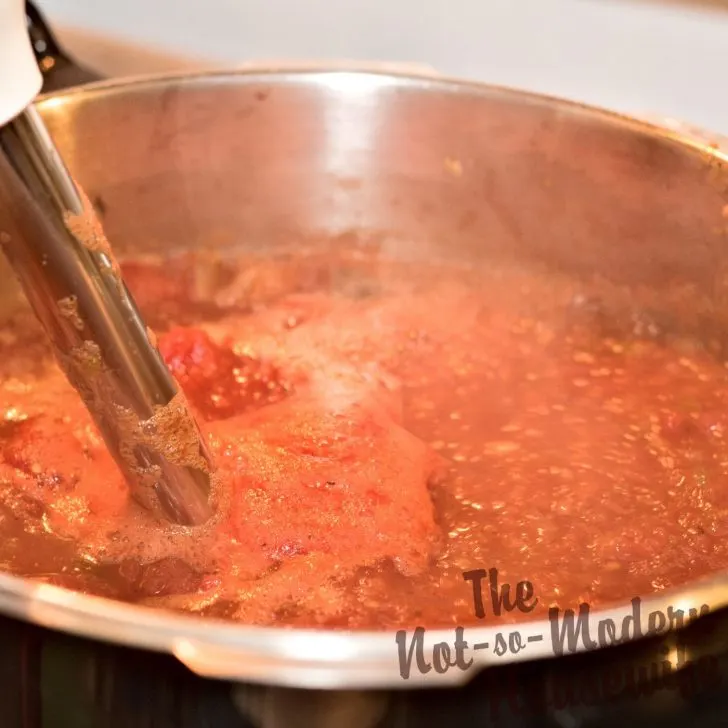 Delicious Restaurant Style Homemade Salsa Recipe with 4 Tips for Water Bath Canning | The Not So Modern Housewife blending cooked salsa with immersion blender