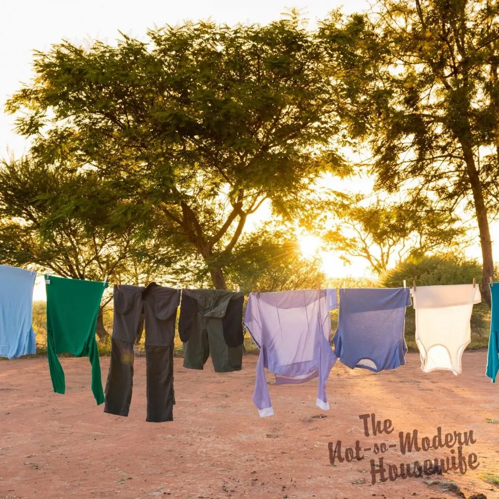 8 Tips to Save Money by Drying Clothes Outside | The Not So Modern Housewife dark and colored clothes hanging on a clothesline