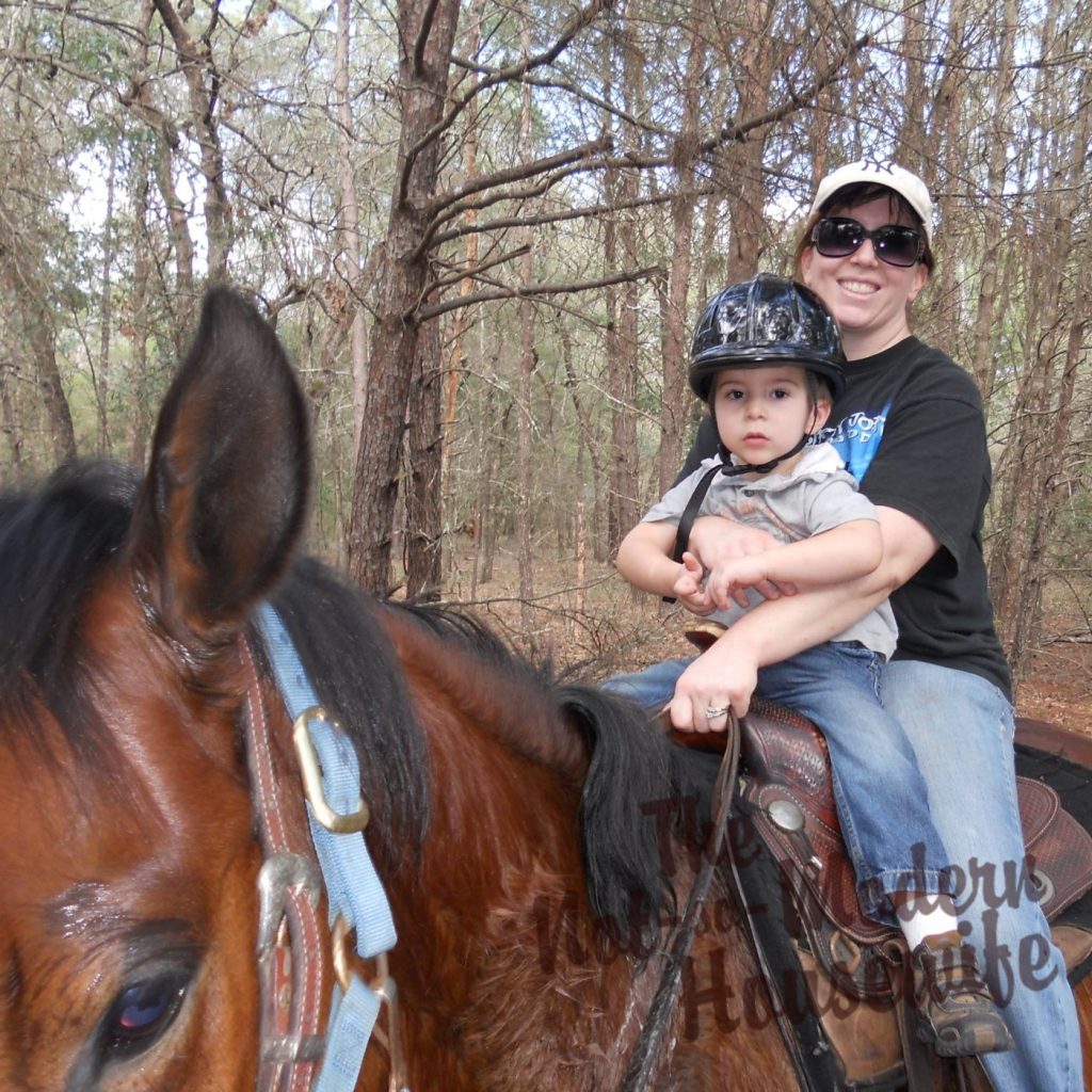 Bonnie Von Dohre and her son riding her horse named Maverick in the woods