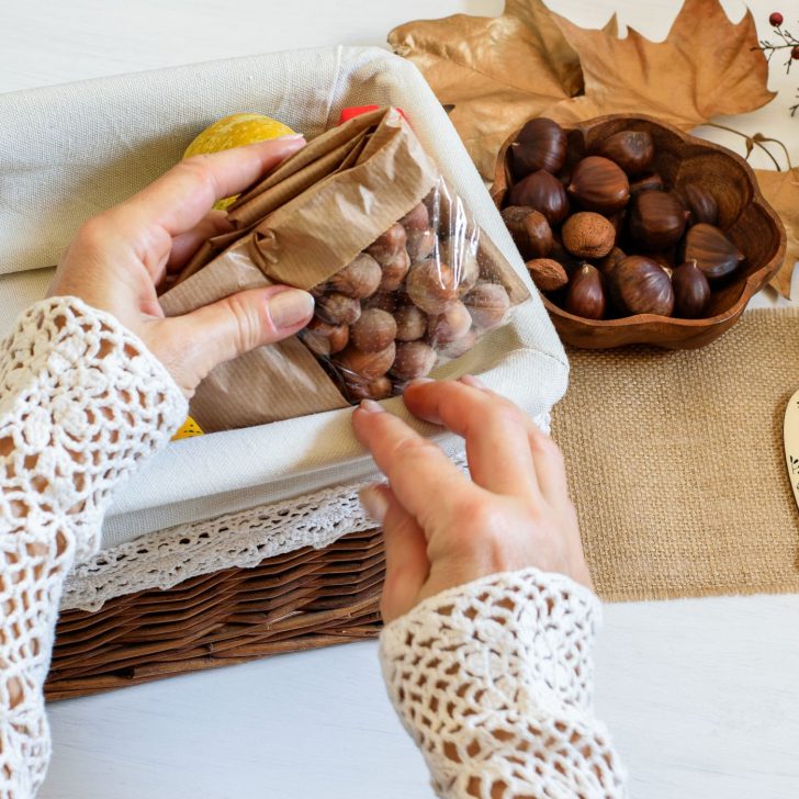hands packing nuts into a gift box - Christmas gift ideas for housewives