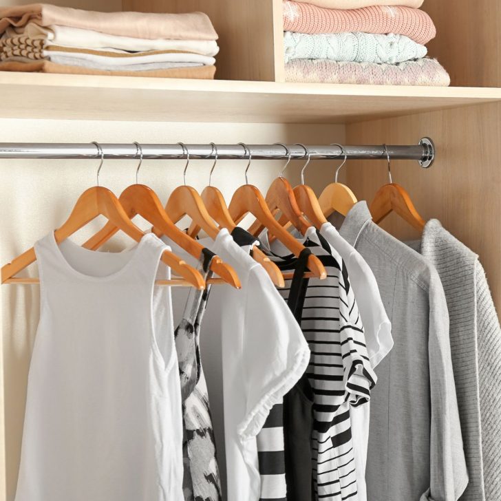 shirts hung neatly in an organized closet - clothing organization ideas